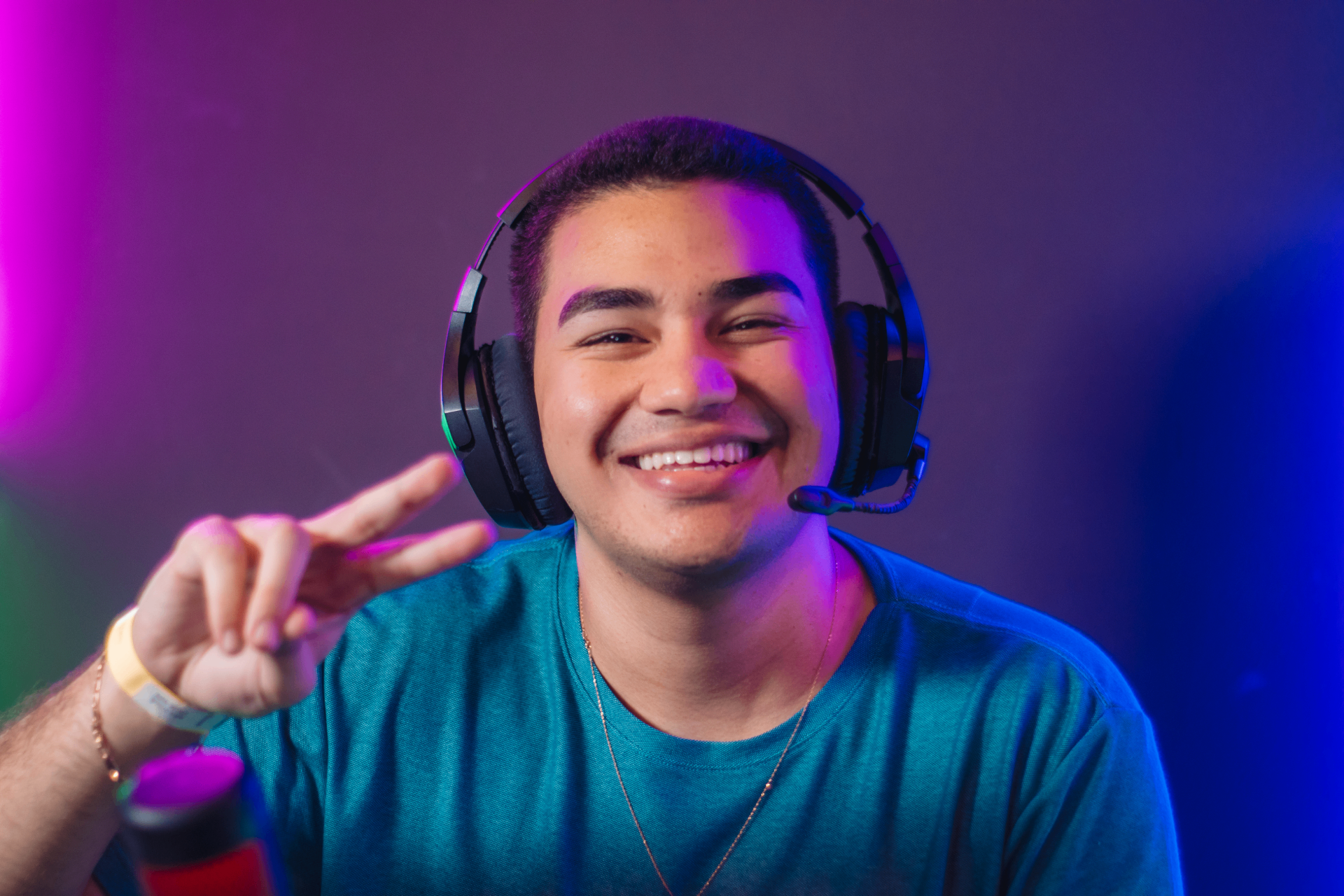 Wolfz sorrindo com headset gamer em ambiente com iluminação neon